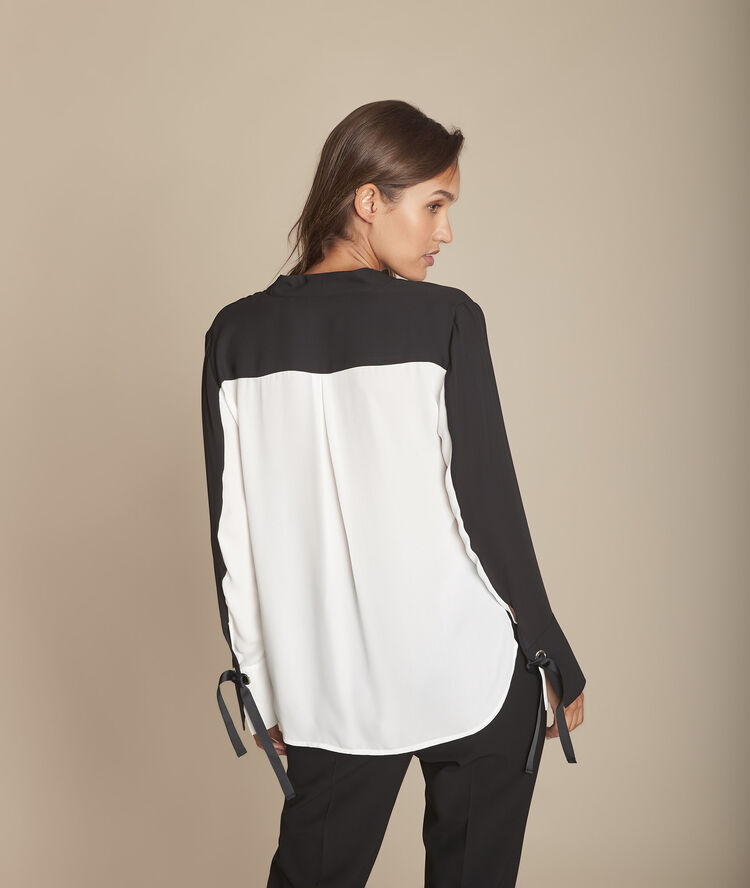 Tweekleurige zwarte blouse met ringetjes aan de polsen marinette noir.
