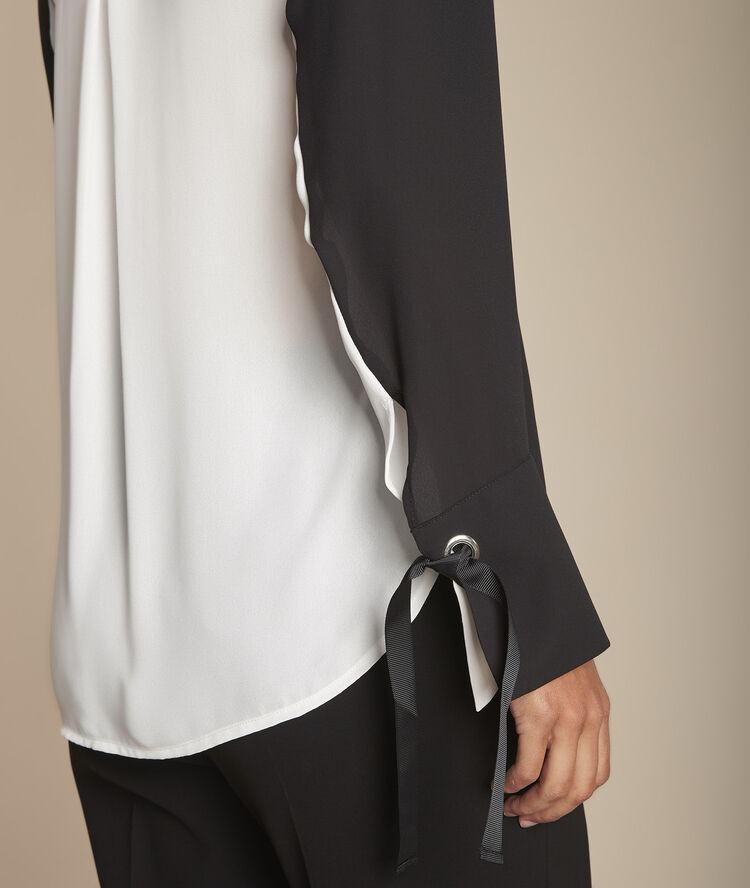 Tweekleurige zwarte blouse met ringetjes aan de polsen marinette noir.