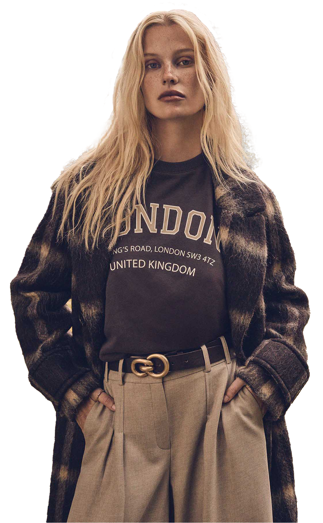 Mannequin portant un sweat London, un manteau à carreaux et un pantalon beige